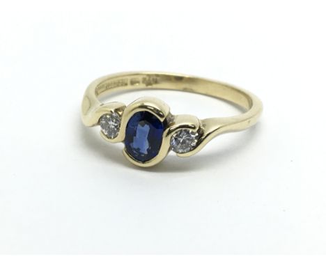 An 18ct gold ring set with a central Ceylon sapphire and two diamonds, approx 3.3g and approx size N.