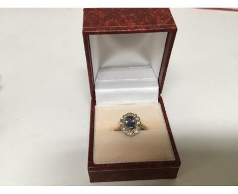 A 9carat gold ring set with a central blue sapphire flanked by round brilliant cut diamonds ring size I