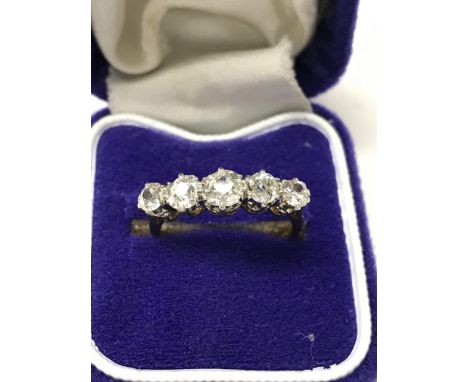 A gold band ring inset with five old cut diamonds size L/ M .
