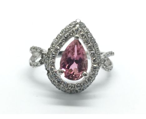 An 18ct white gold ring set with a central pink sapphire and surrounded by diamonds, approx 4.9g and approx size N.