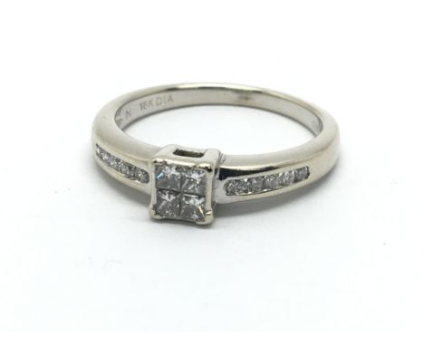 An 18ct white gold ring, set with four approx 0.25ct princess cut diamonds and diamonds to the shoulders, approx 3.2g, ring s