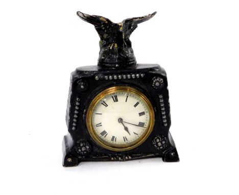 A late 19thC Continental black painted metal mantel clock, circular white enamel dial bearing Roman numerals, clockwork movem