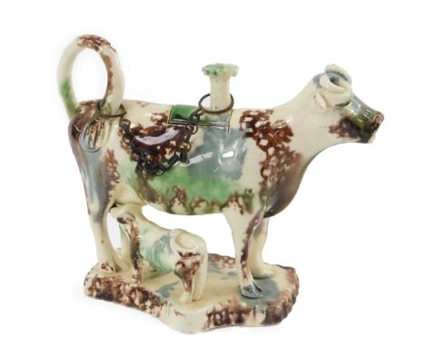 An early 19thC Staffordshire pearl ware cow creamer, modelled standing with a calf, lid with mushroom finial, looped tail han
