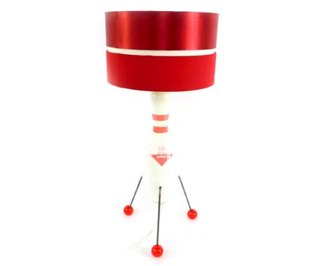 An Atomic style table lamp, the body formed as a ten pin bowl Amflite II, raised on three metal rod legs, with ball feet, and