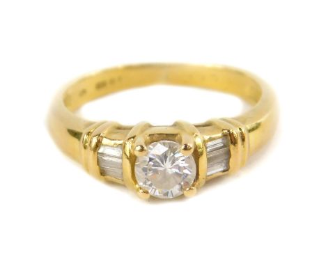 An 18ct gold and diamond ring, in a stepped setting, with one brilliant diamond flanked by four baguette cut diamonds, approx