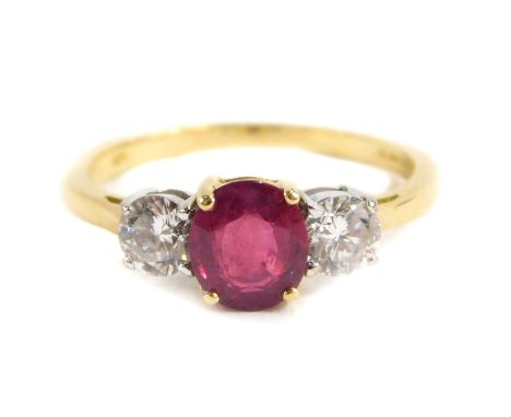 An 18ct gold ruby and diamond three stone ring, central set with oval cut ruby approx 6.62mm x 5.80mm x 2.95mm depth, total e