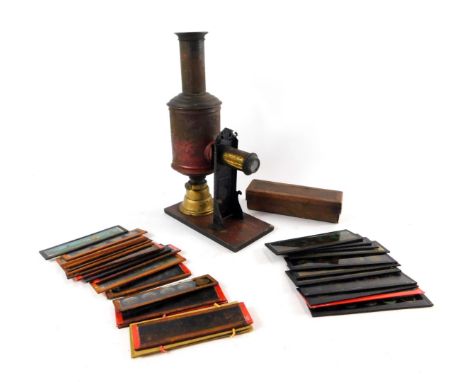 A Victorian tin and brass magic lantern, together with magic lantern slides. (qty)