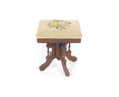 A Victorian oak piano stool, the carved rectangular top with over stuffed tapestry seat decorated with roses, raised on a qua