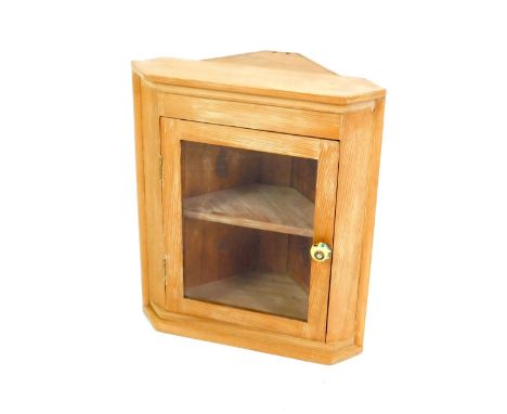 A pine hanging corner cupboard, with a glazed door opening to reveal a single shelf, 55cm H, 47cm W, 25cm D.