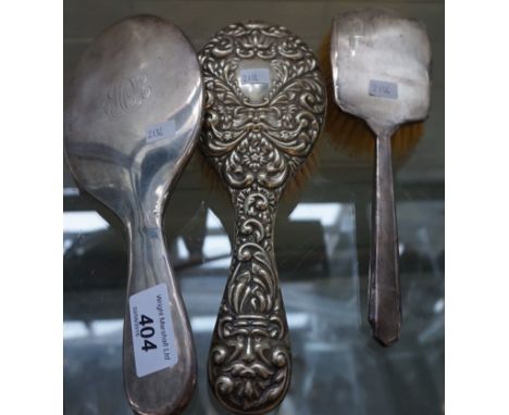 A mixed lot of three silver backed dressing table items to include a hand mirror, hairbrush and a further Birmingham hallmark