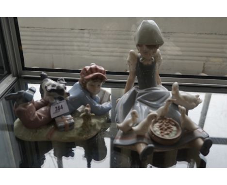 Two Lladro figurines to include a girl sat feeding geese and a boy reading a book with a dog playing on his back.