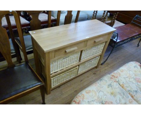 A good quality modern light oak hall cabinet, comprising two single drawers above two tiered shelf, each containing two wicke