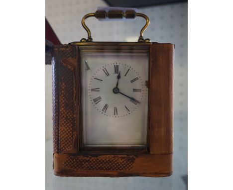 A rectangular brass cased carriage clock with enamel dial set within original leather case.