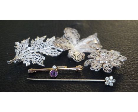 An amethyst and seed pearl broochTo yellow metal, together with, three white metal filigree brooches and a paste stick pin (5