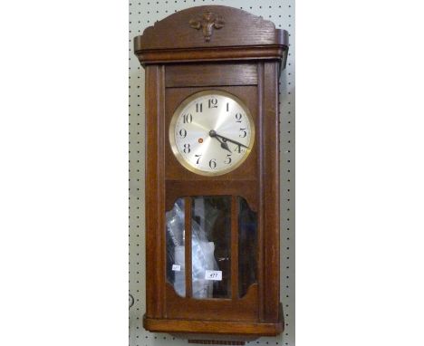 An early 20th Century light oak wall clock.
