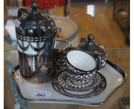 An unusual ceramic tea service to include sugar bowl, milk jug, two cups and saucers, and a teapot with tray, all mounted wit