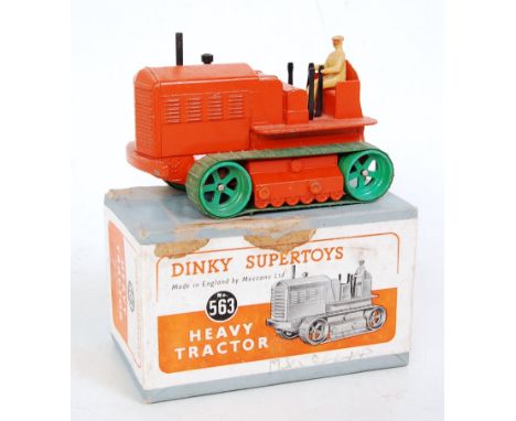 A Dinky Toys No. 563 heavy tractor comprising orange body with green tracks and tan driver, in the original lift-off lid all-