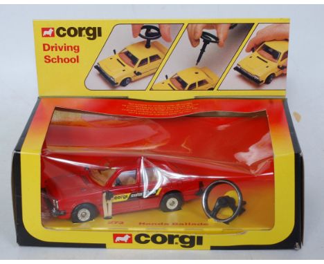 A Corgi Toys No. 273 Honda Ballade Motor School comprising red body with brown interior and steering wheel attachment, in the