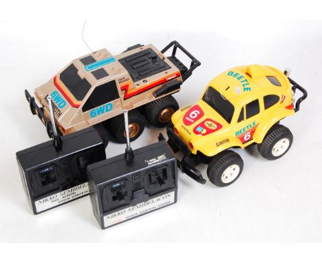 Two loose working Nikko remote control cars with hand units to include the Nikko Mammoth 1/18 scale combat 6WD Tronico togeth