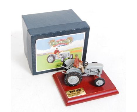 A Britains No. 8711 Ferguson TE20 tractor comprising grey body with driver figure raised on anniversary wooden display plinth