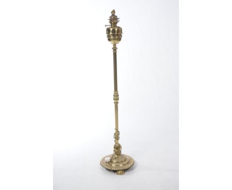 A large polished brass standard lamp, circa 1900.
The circular base with lappet border, raised on compressed bun feet. The sl