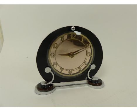 An Art Deco clock,having a circular peach mirror dial, raised on chrome supports, Patent no 445969, 19.5 x 23 x 6.5cm.