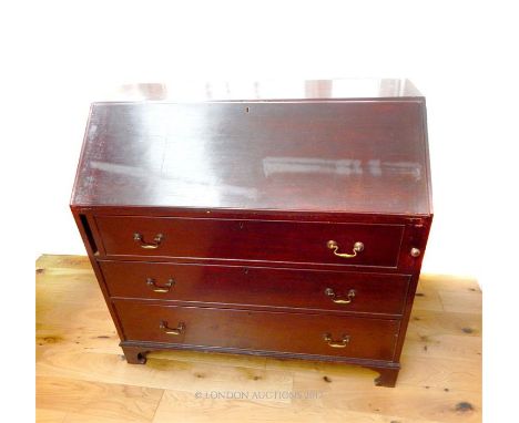 A Georgian mahogany bureau, the fall front opening to reveal a fitted interior, above three long graduated drawers, raised on