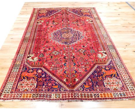 A fine Southwest Persian Qashqai carpet, having a medallion on a red field with spandrels, surrounded by one frieze and two r