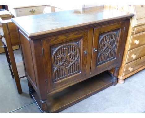 An Elizabethan Style Oak Sideboard, the sideboard having carved front panel on turned legs with shelf below, approx 86 x 101 