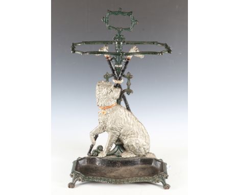 A late Victorian cold painted cast iron stick stand, decorated in relief with a Highland terrier above a shaped drip tray and