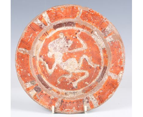 A Mexican pottery plate, probably Mixtec civilization, circa 1100-1400 AD, painted in red and orange pigments with a dancing 