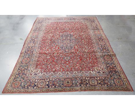 A Tabriz carpet, Central Persia, early 20th century, the claret field with a shaped medallion, within a blue palmette and flo