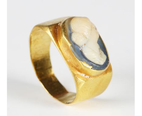 A Roman gold ring, the bezel inset with a white overlaid blue glass cameo depicting a female bust, width 1.7cm. Note: from th