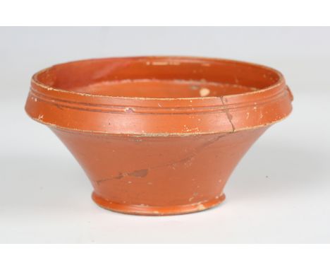 A Roman Samian ware cup, 2nd century AD, the inverted rim sprigged with opposing dolphins, diameter 12cm (faults and restorat