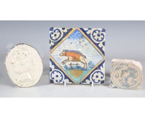 A small 18th century Continental tin glazed blue and white floor tile, detailed with a stylized portrait, 7.5cm x 7cm, togeth