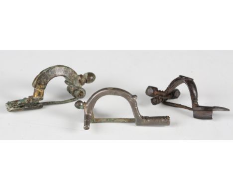 A Roman silver crossbow type brooch, length 6cm, together with two other copper alloy crossbow brooches. Note: from the estat