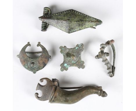 A Roman copper alloy skeumorphic plate type brooch in the form of a cornucopia, length 6cm, together with a group of four oth