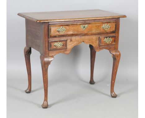 An 18th century oak side table with mahogany crossbanded borders, fitted with three drawers, raised on cabriole legs with pad