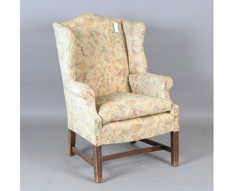 A 20th century George III style wingback armchair, upholstered in foliate machined tapestry style fabric, height 102cm, width