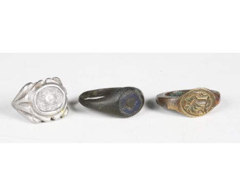 A Roman copper alloy ring, the oval bezel with central dot and blue enamel surround, width 12.5cm, together with six other ri