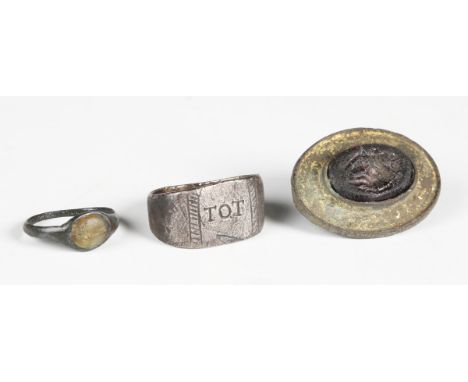 A Roman gilt copper alloy oval disc brooch, the centre inset with a moulded glass intaglio, 3.2cm x 2.3cm, together with a Ro