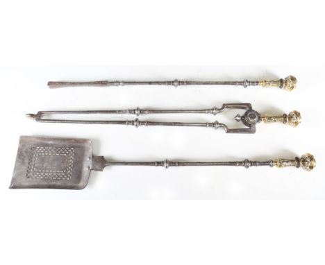 A set of three George III steel and brass fire tools with acanthus leaf cast knop handles above turned shafts, length of shov