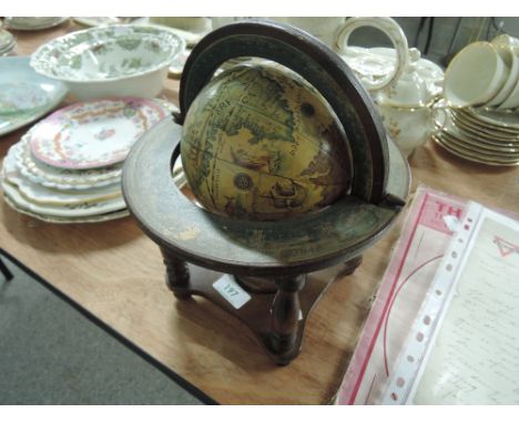 A globe mounted on a treen base decorated with the months of the year and zodiac signs