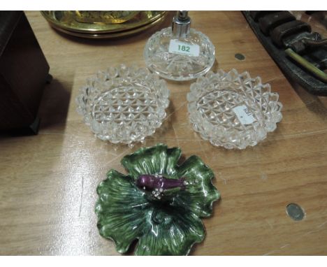 Two cut glass pin dishes, a cut glass perfume bottle and an enamel pin dish with bird decoration