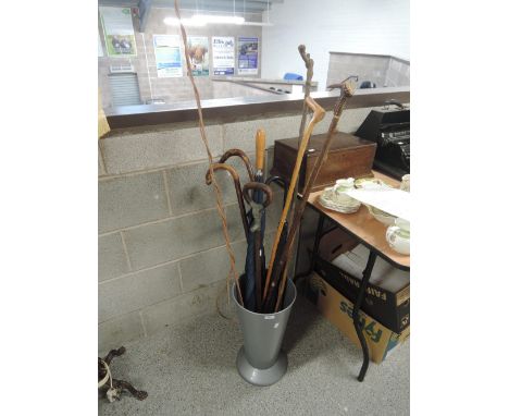 A selection of walking sticks including antler handled and driving whip in stick stand