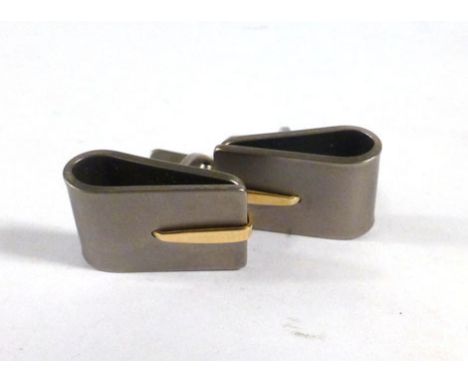 A pair of yellow metal mounted titanium cufflink's