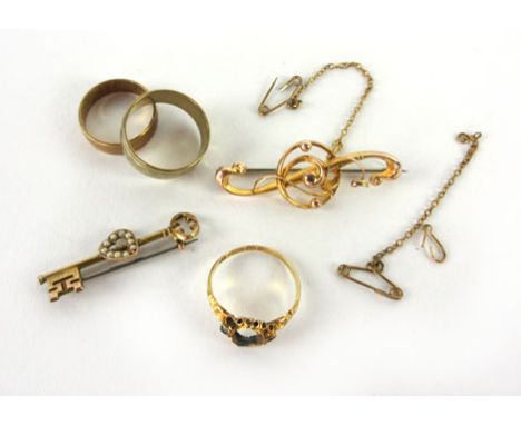 A small parcel of 9ct yellow gold jewellery consisting two wedding bands an two brooches, one in the form of a key, overall 9