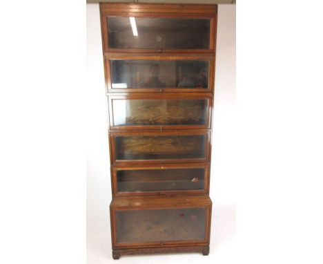 A four section oak Globe Wernicke sectional bookcase with two similar but unlabeled sections, plus plinth and cornice section