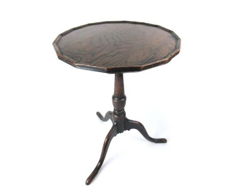 An 18th century oak tripod table the faceted and moulded top on a turned column and three legs. h. 64 cm, dia 47 cm   CONDITI