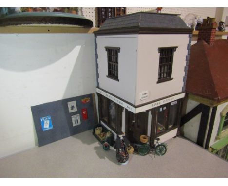 A two storey dolls house as a Post Office and village shop, the ground floor fitted as shop with two bisque dolls, furniture 